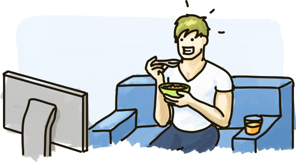 A man looks very happy while eating his breakfast in front of the television.